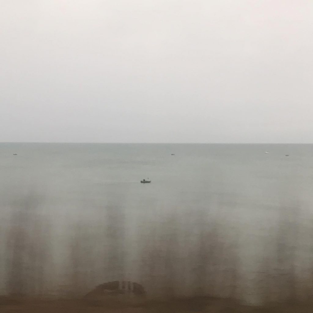 Small fishing boat on a lake seen from the distance.