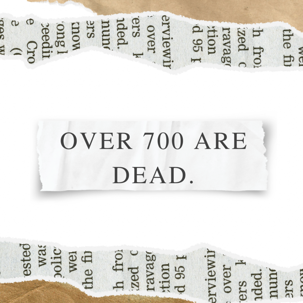 Torn papers in the background. A small scrap of paper shows the headline "Over 700 are dead."
