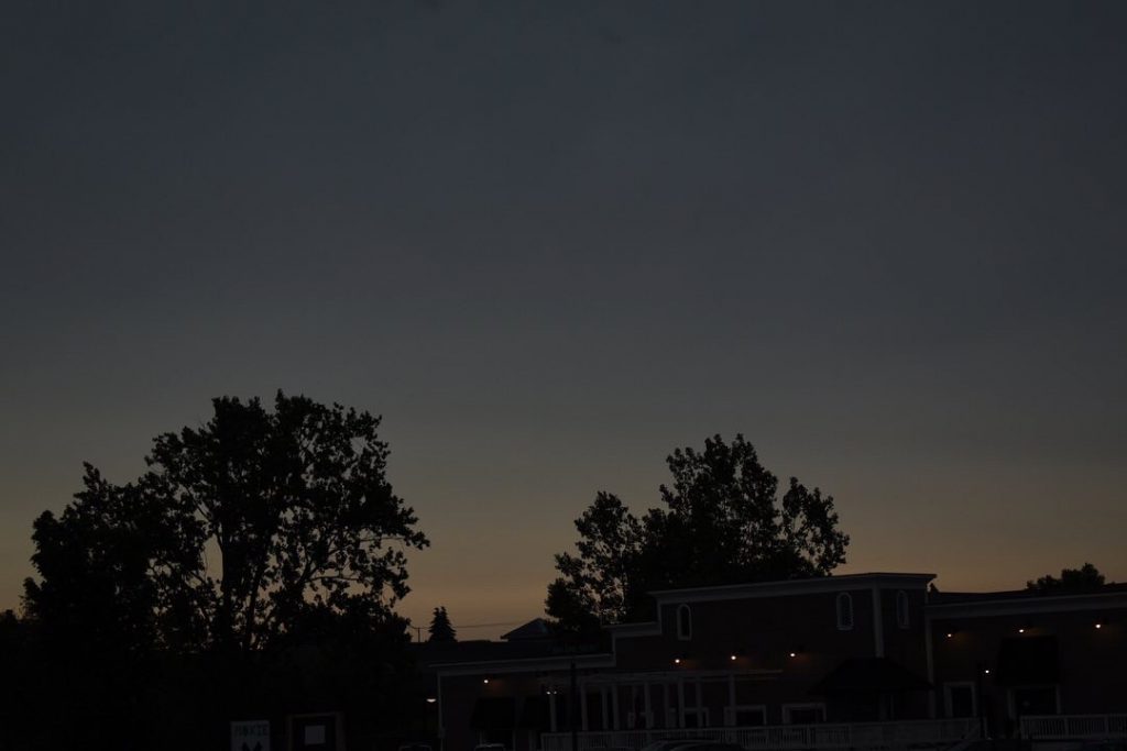 Sunset with buildings and trees.